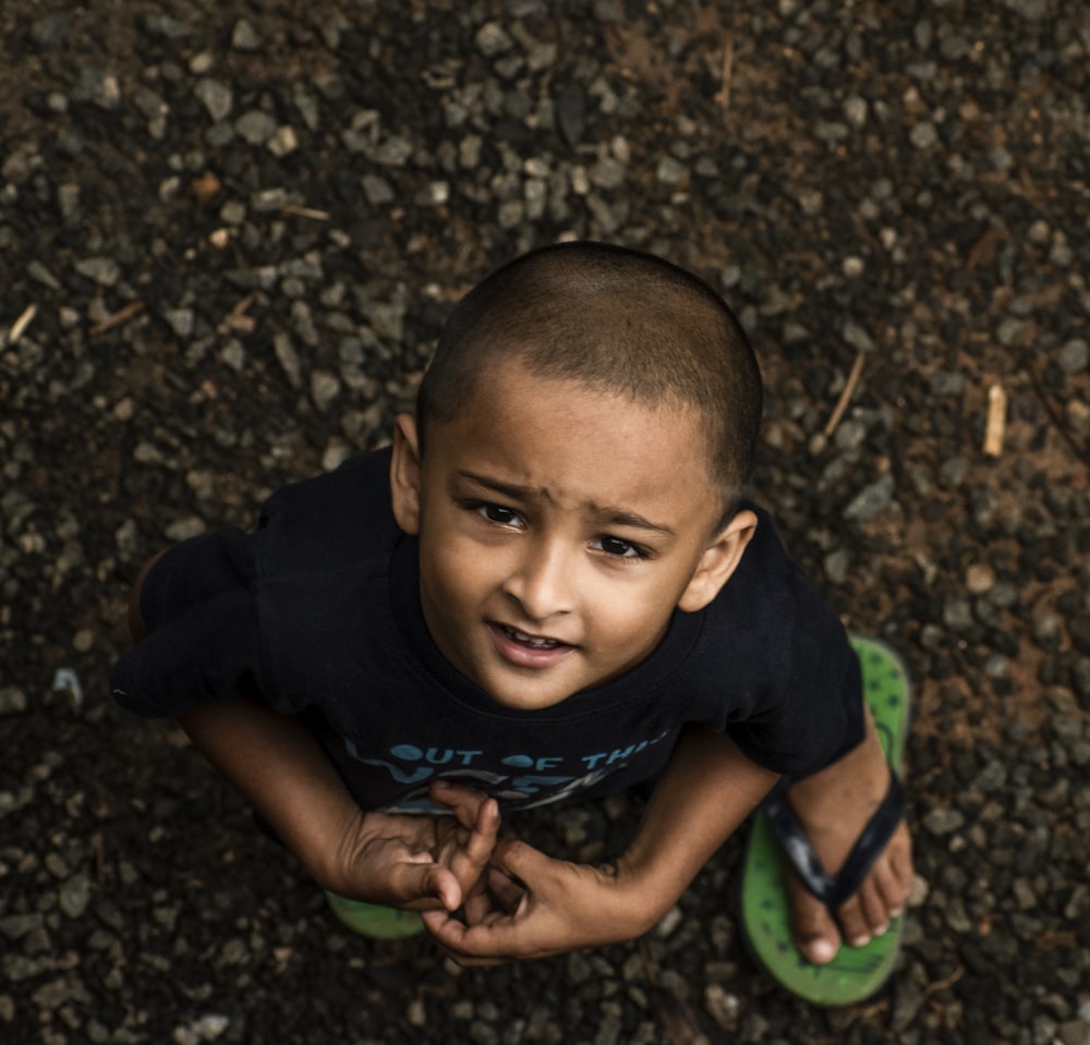 a young boy sitting on top of a green frisbee