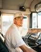 a man with a tattooed arm driving a bus