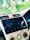 A car's dashboard display screen shows a music player interface with the song 'Thoda Thoda Pyaar' by Stebin Ben. The dashboard features various controls for air conditioning and audio settings. The screen indicates Bluetooth connectivity.