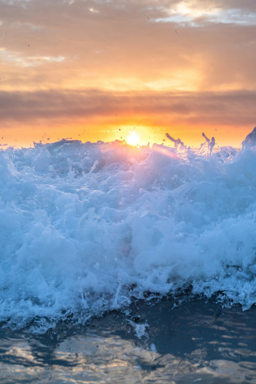 the sun is setting over the ocean waves