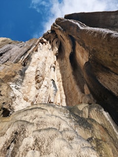 a very tall rock with a sky in the background