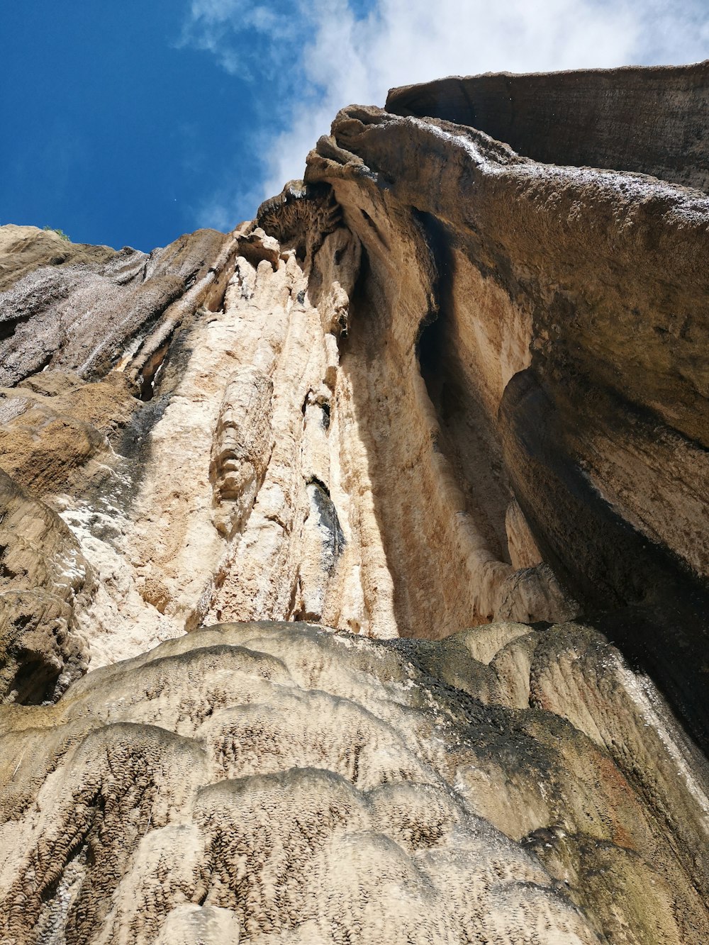 a very tall rock with a sky in the background