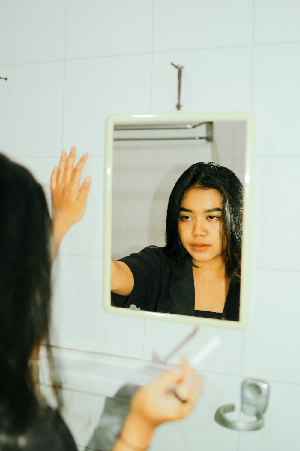 a woman is looking at her reflection in the mirror