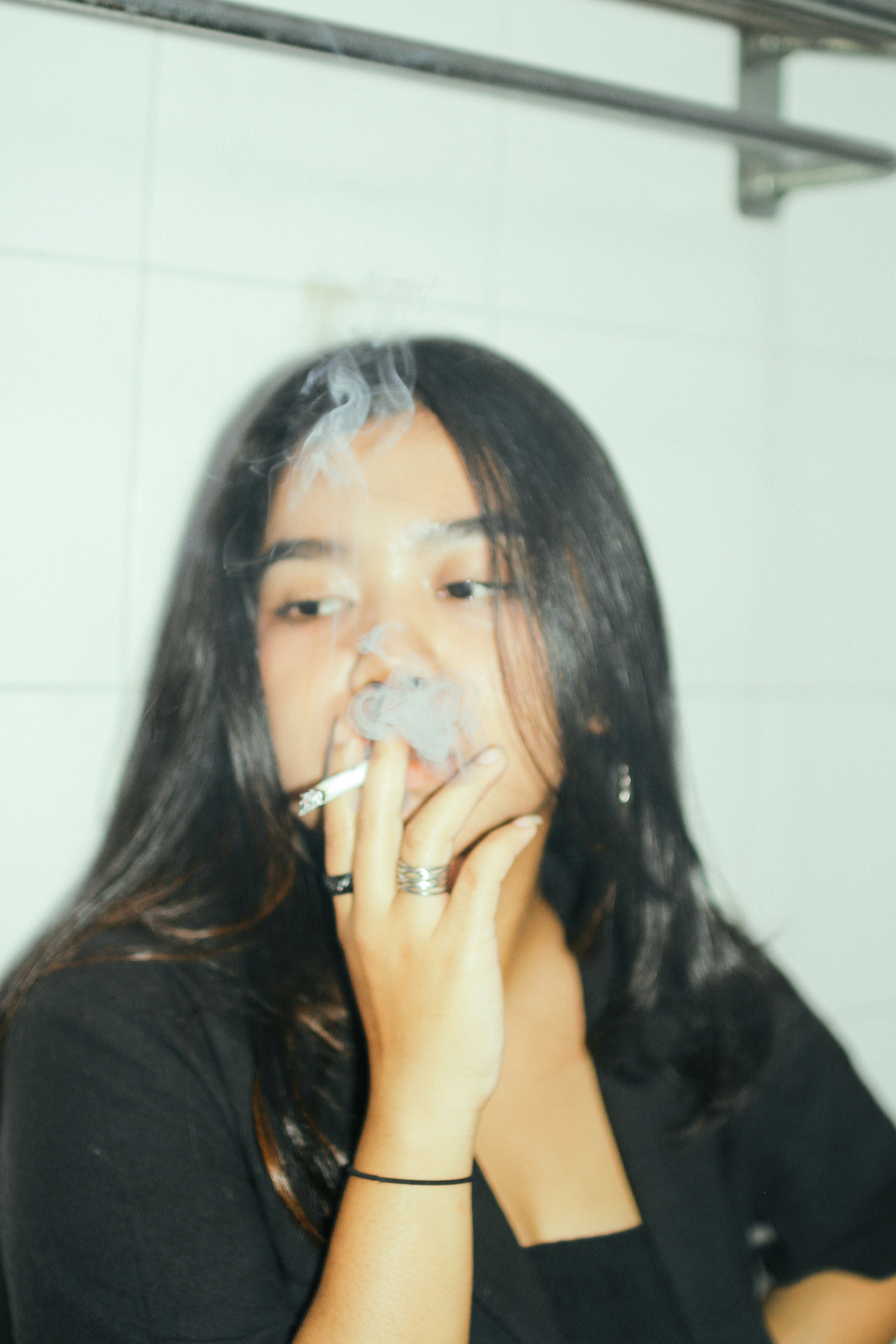 a woman smoking a cigarette in a bathroom