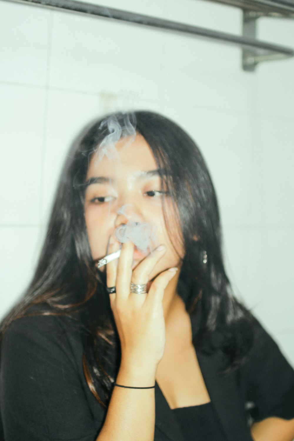 a woman smoking a cigarette in a bathroom