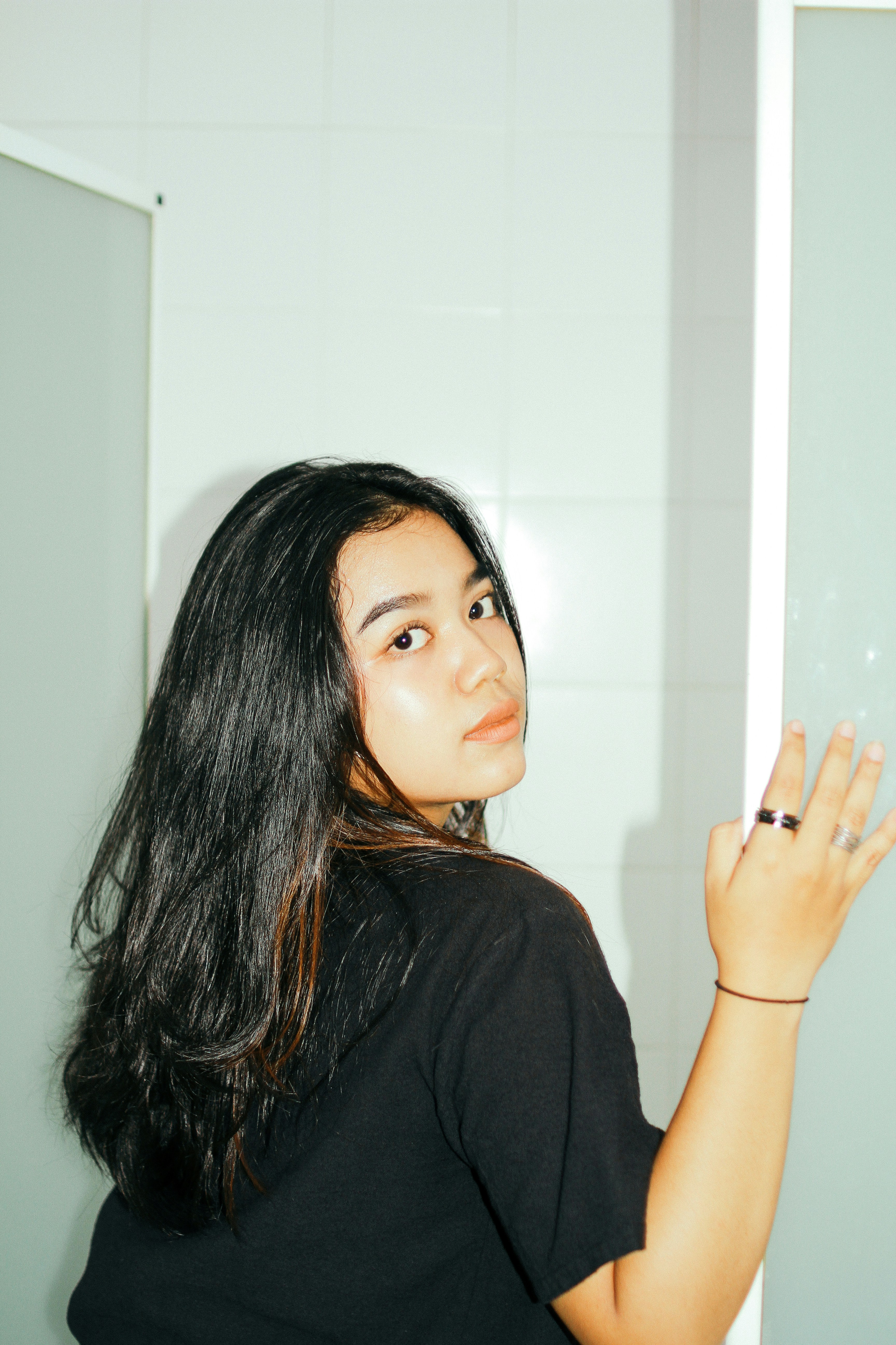 a woman standing in front of a mirror in a bathroom