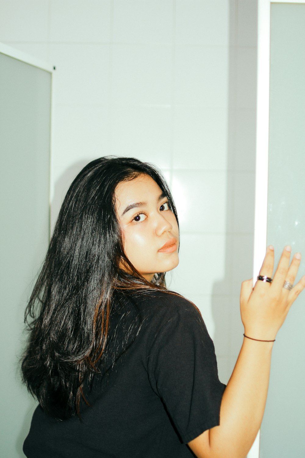 a woman standing in front of a mirror in a bathroom