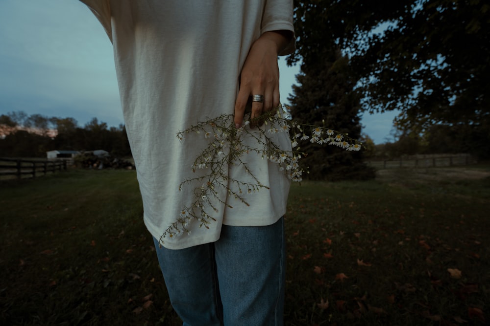 a person standing in a field holding a plant