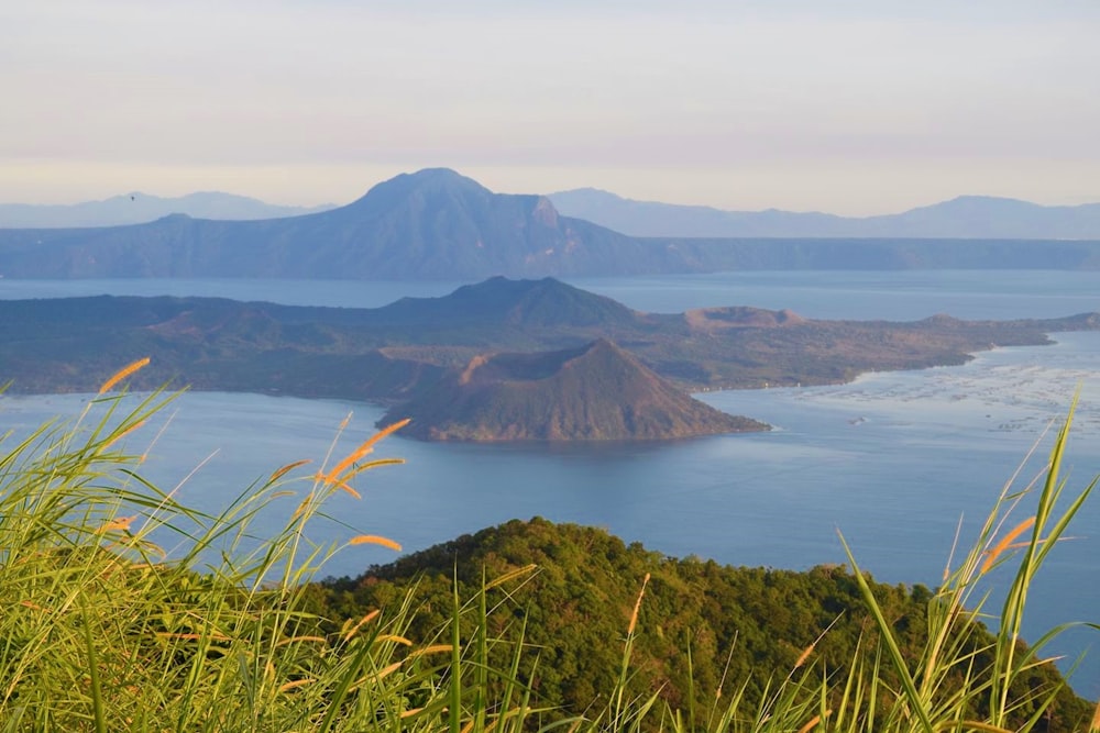 Una vista de un lago y montañas desde la cima de una colina