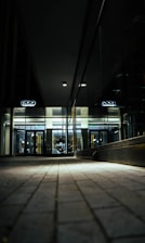A sleek, dark-themed office lobby with a person seamlessly entering through a glass door using k-less technology.