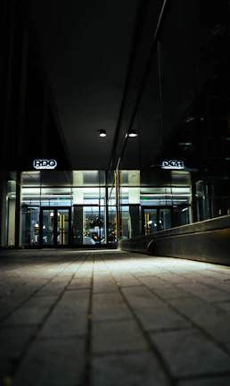 A gleaming office lobby with polished floors and shining glass surfaces under soft golden lighting.