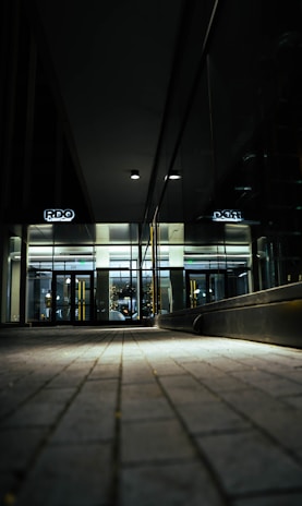 A sleek, dark-themed office lobby with a person effortlessly entering through a glass door using hands-free access.