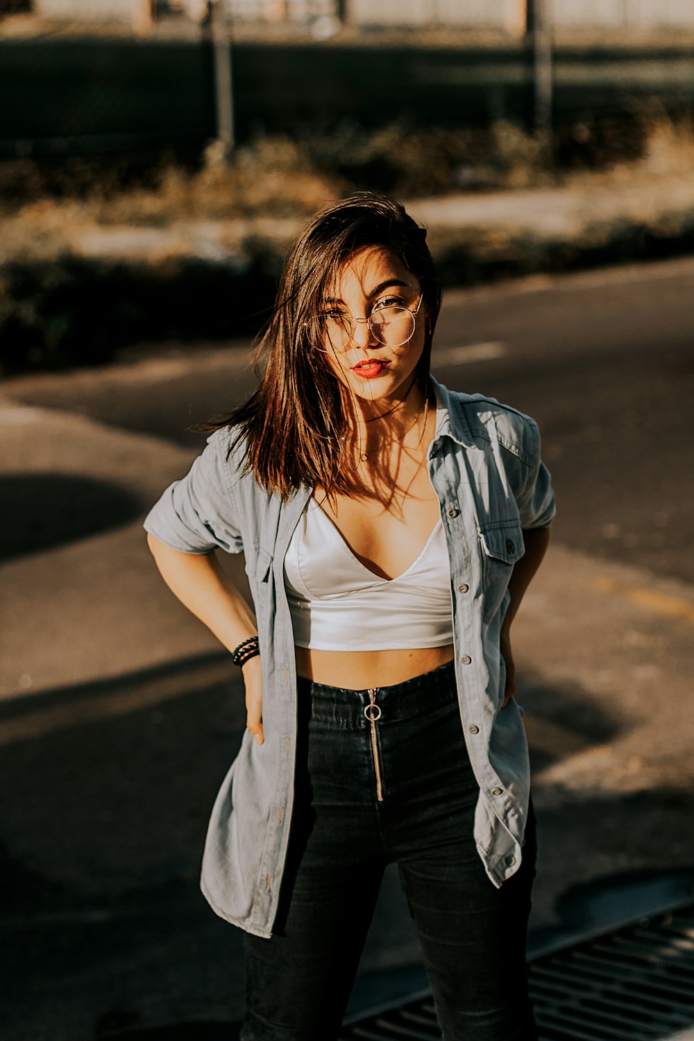 a woman standing on the side of a road