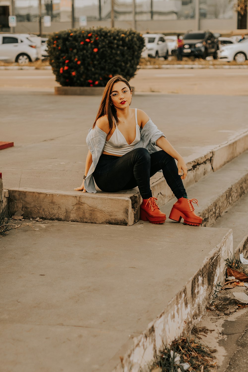 a woman sitting on the steps of a parking lot