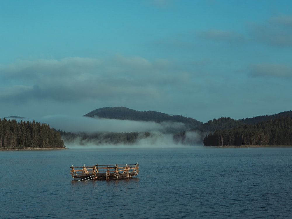 a boat floating on top of a lake next to a forest