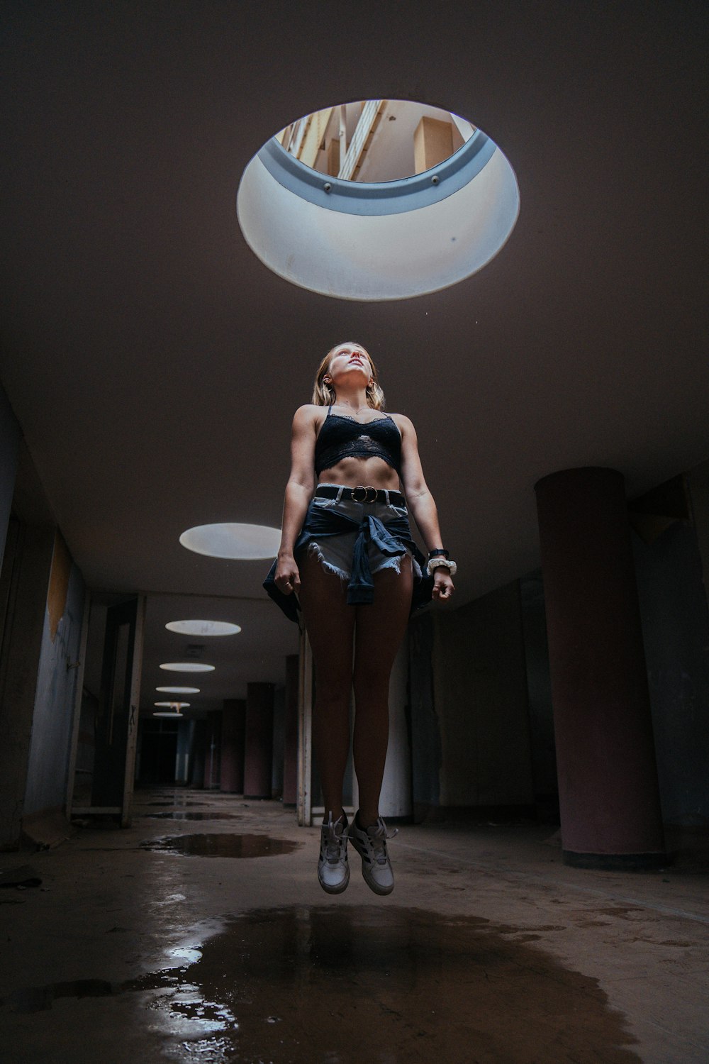 a woman standing in a hallway with her legs crossed