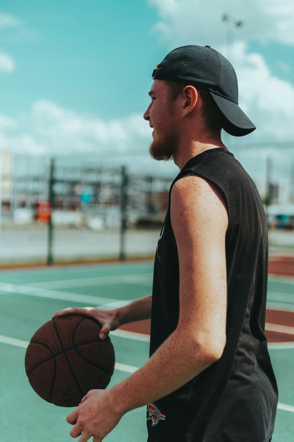 Un hombre sosteniendo una pelota de baloncesto en una cancha de baloncesto