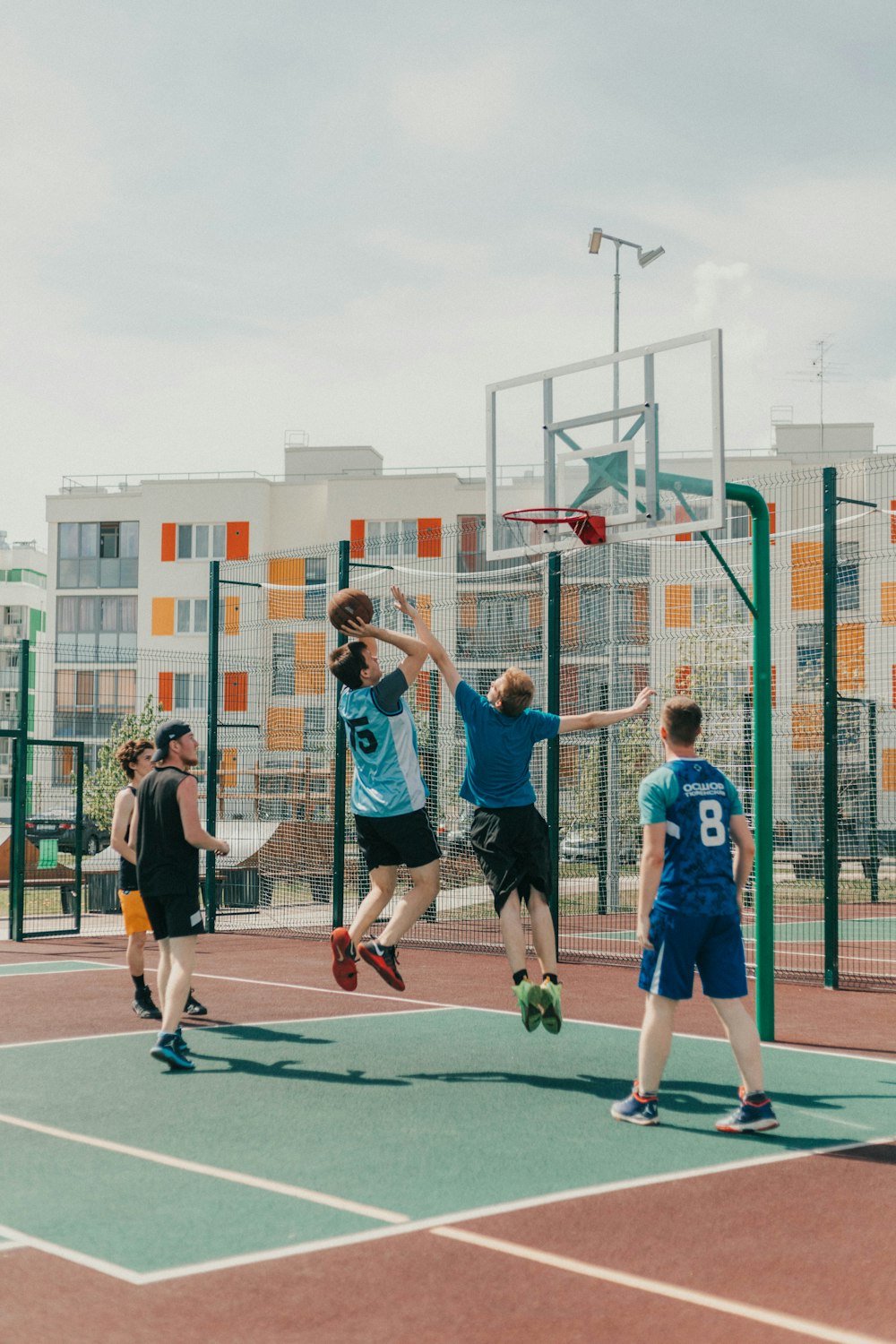 a group of young men playing a game of basketball