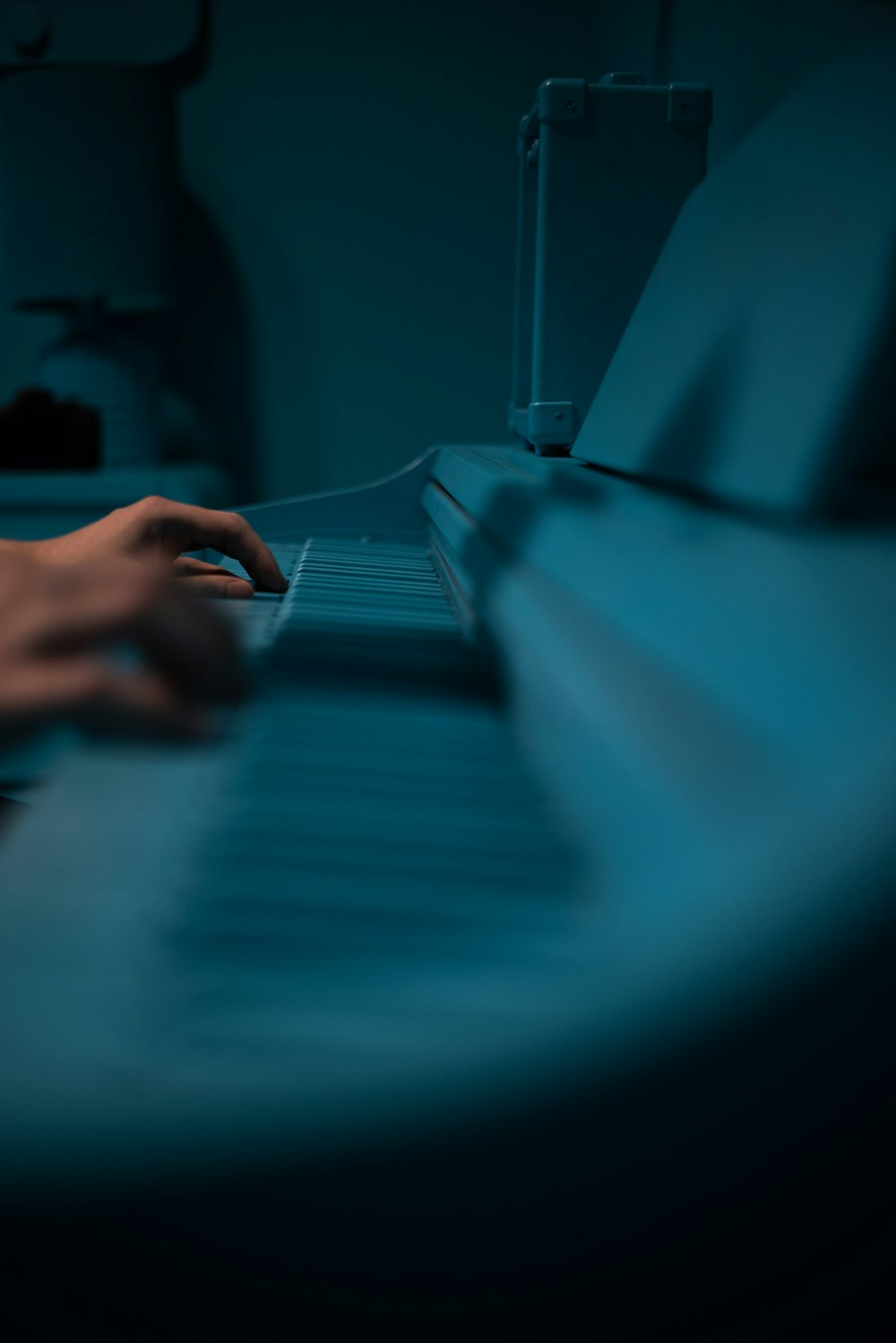 a person is playing a piano in a dark room