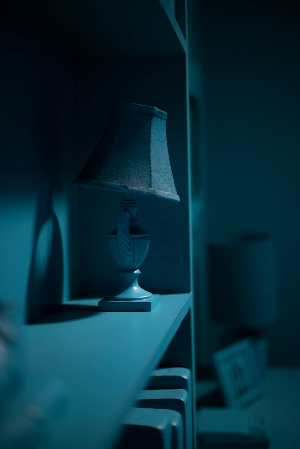 a lamp sitting on top of a table next to a book shelf