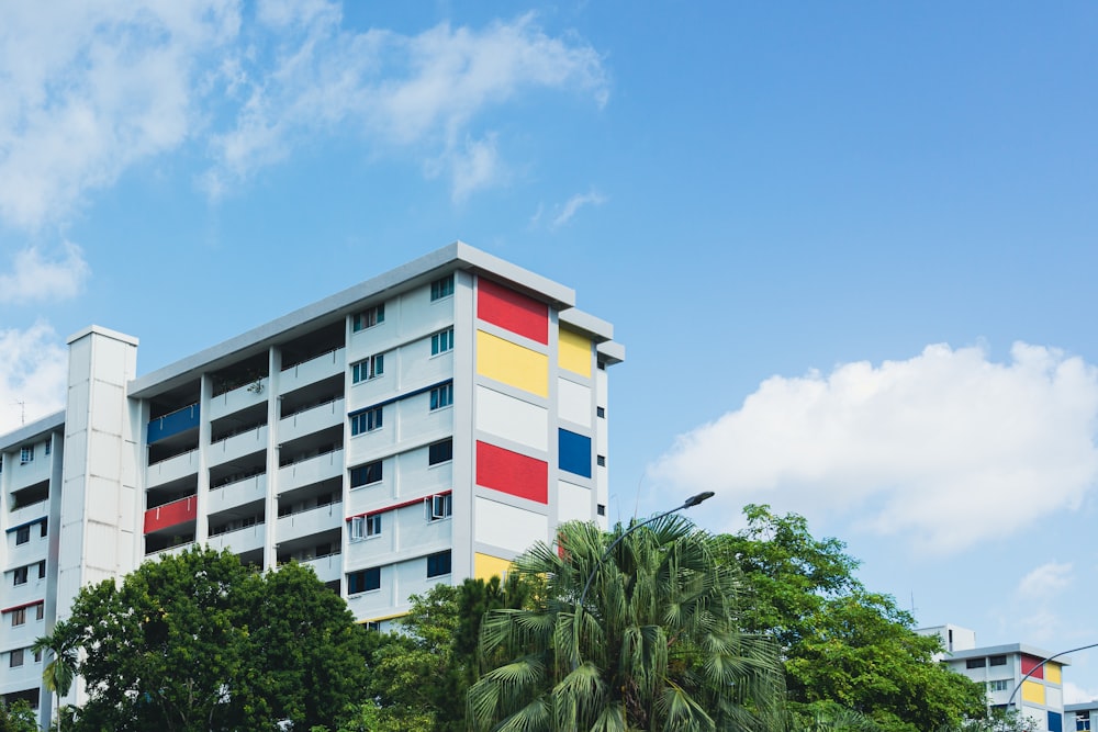 a multi - colored building with palm trees in front of it
