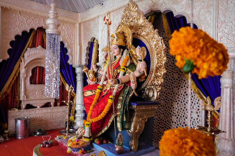 a statue of a hindu god sitting on a throne