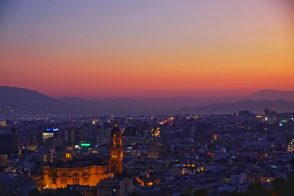 Una vista di una città di notte con le montagne sullo sfondo