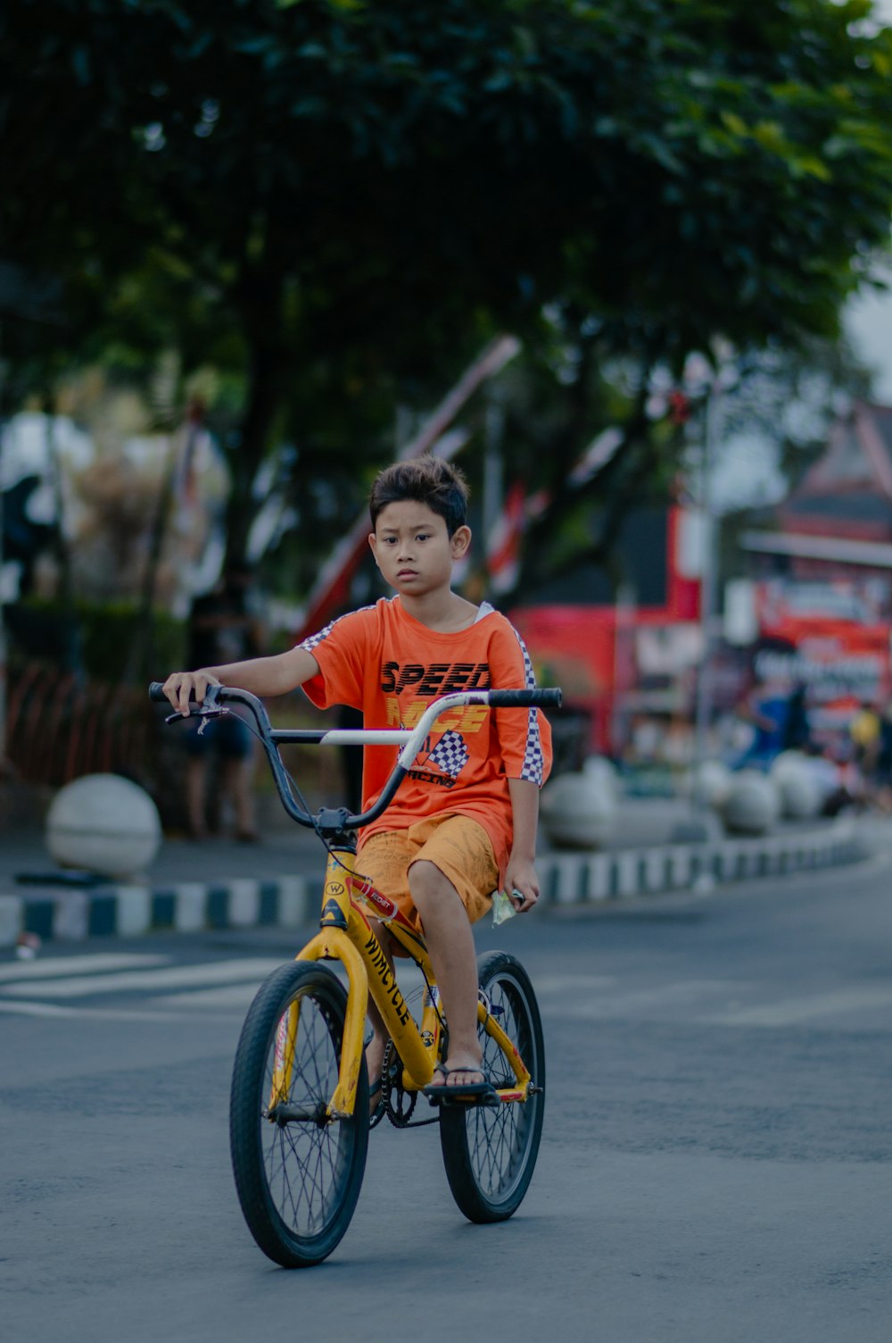 a young boy riding a bike down a street