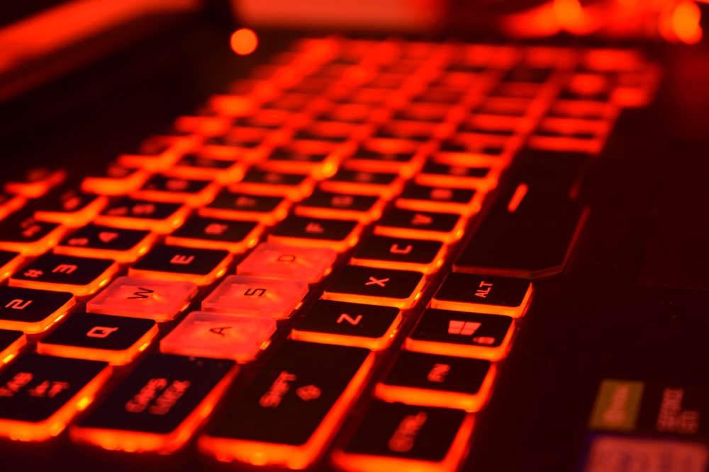 a close up of a computer keyboard with red light