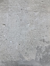 a red fire hydrant sitting on the side of a cement wall