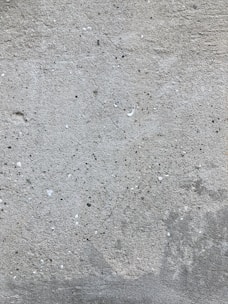 a red fire hydrant sitting on the side of a cement wall
