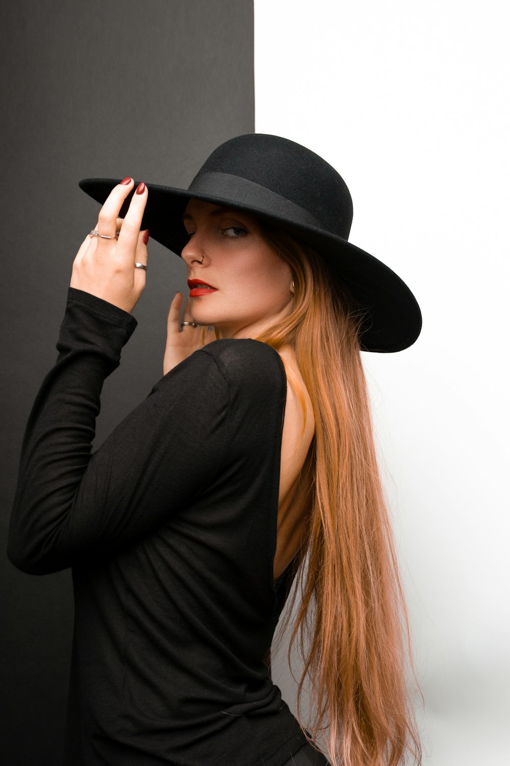 Eine Frau mit langen Haaren trägt einen schwarzen Hut