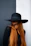 a woman with long red hair wearing a black hat