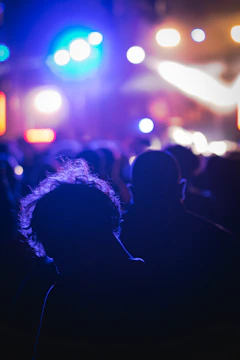 Colorful stage lights shining over a crowd worshipping at a live concert.