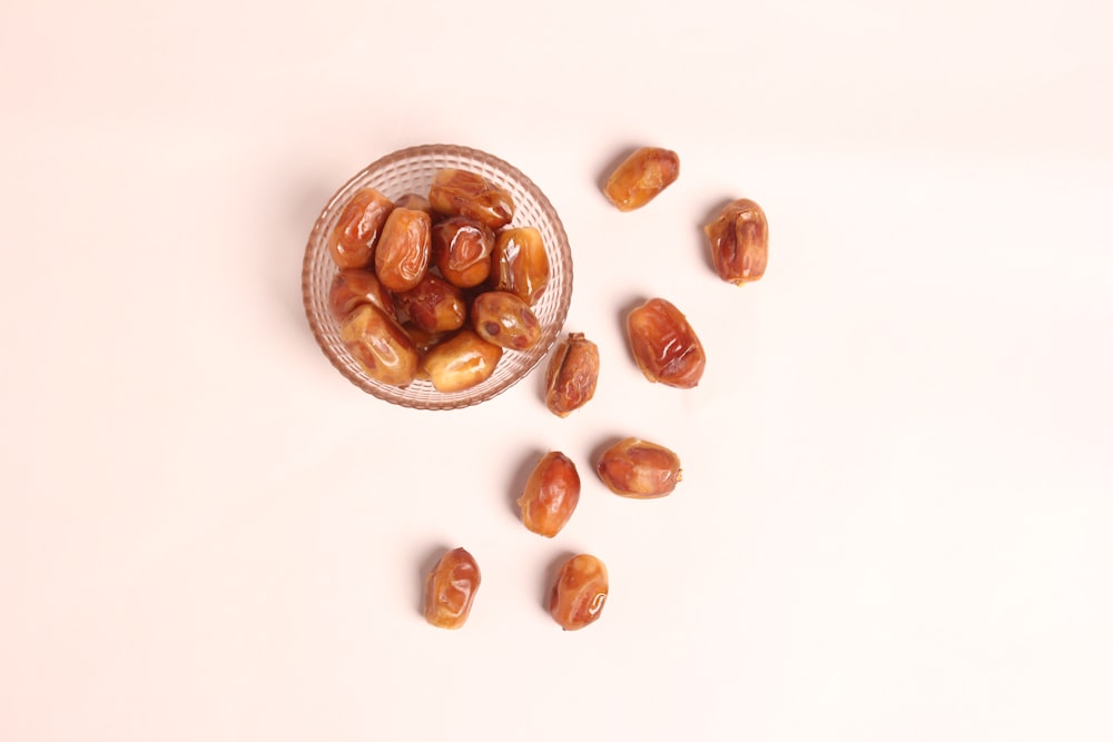 a glass bowl filled with nuts on top of a table