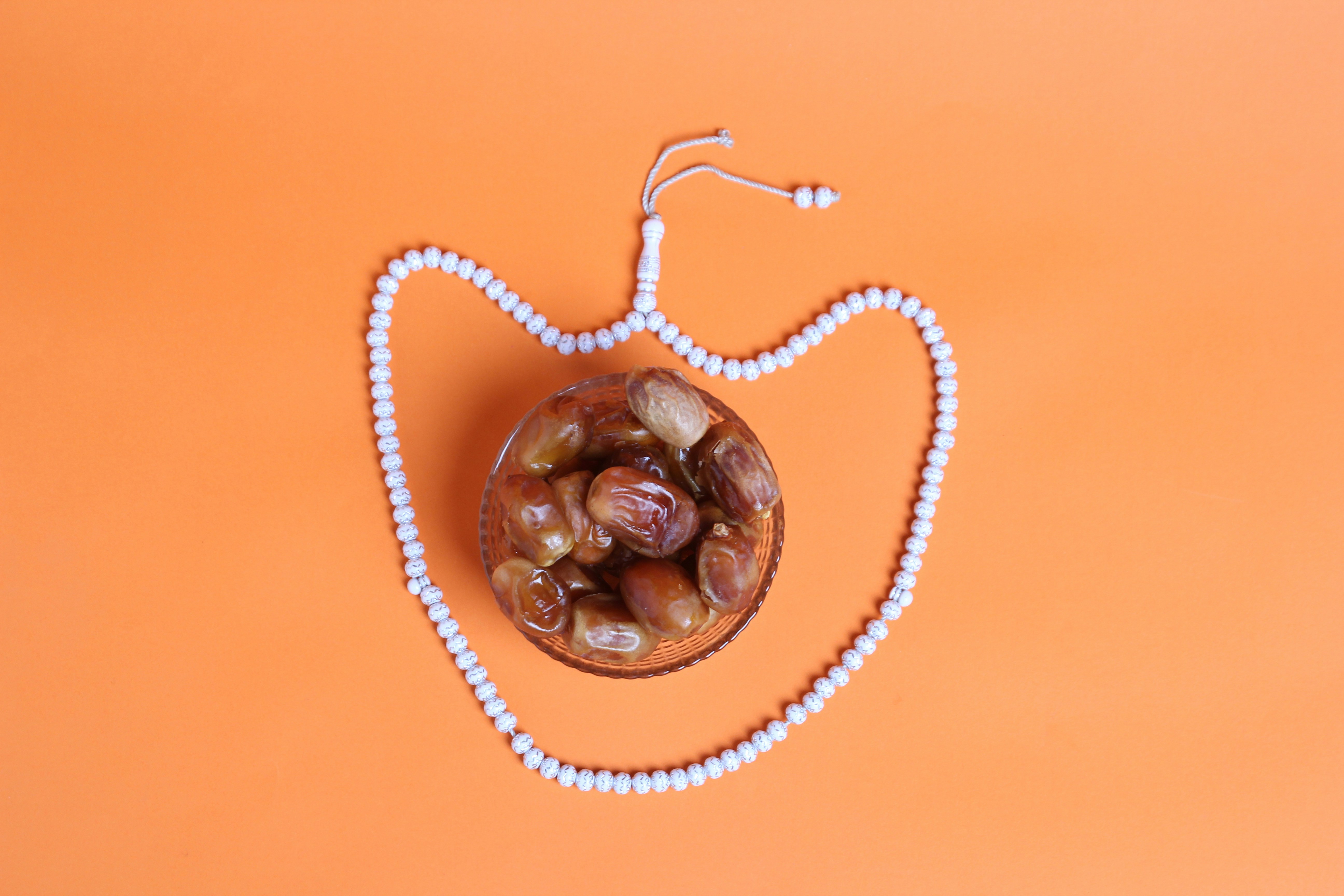 a beaded necklace with beads and nuts on an orange background