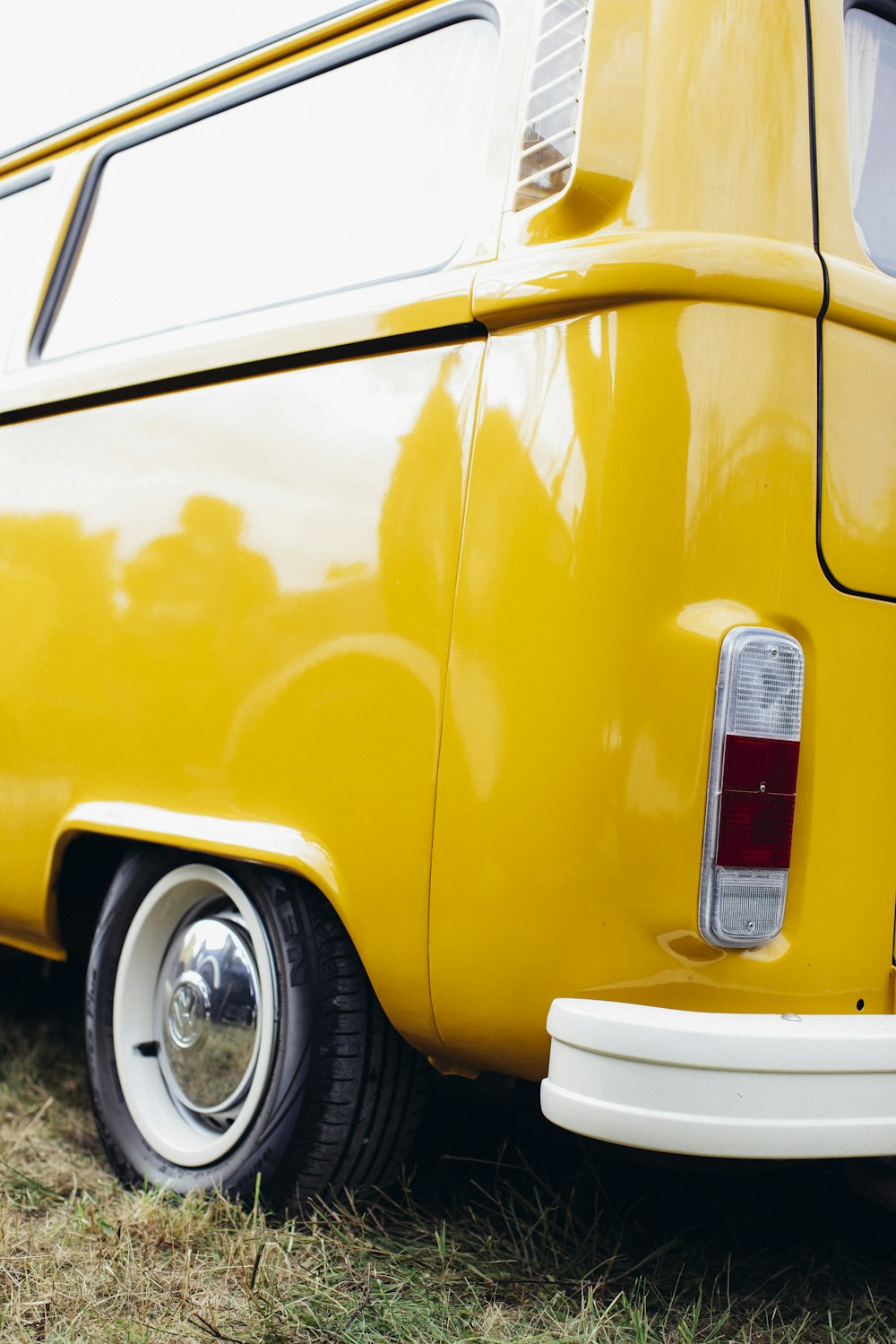 a close up of a yellow van parked in a field