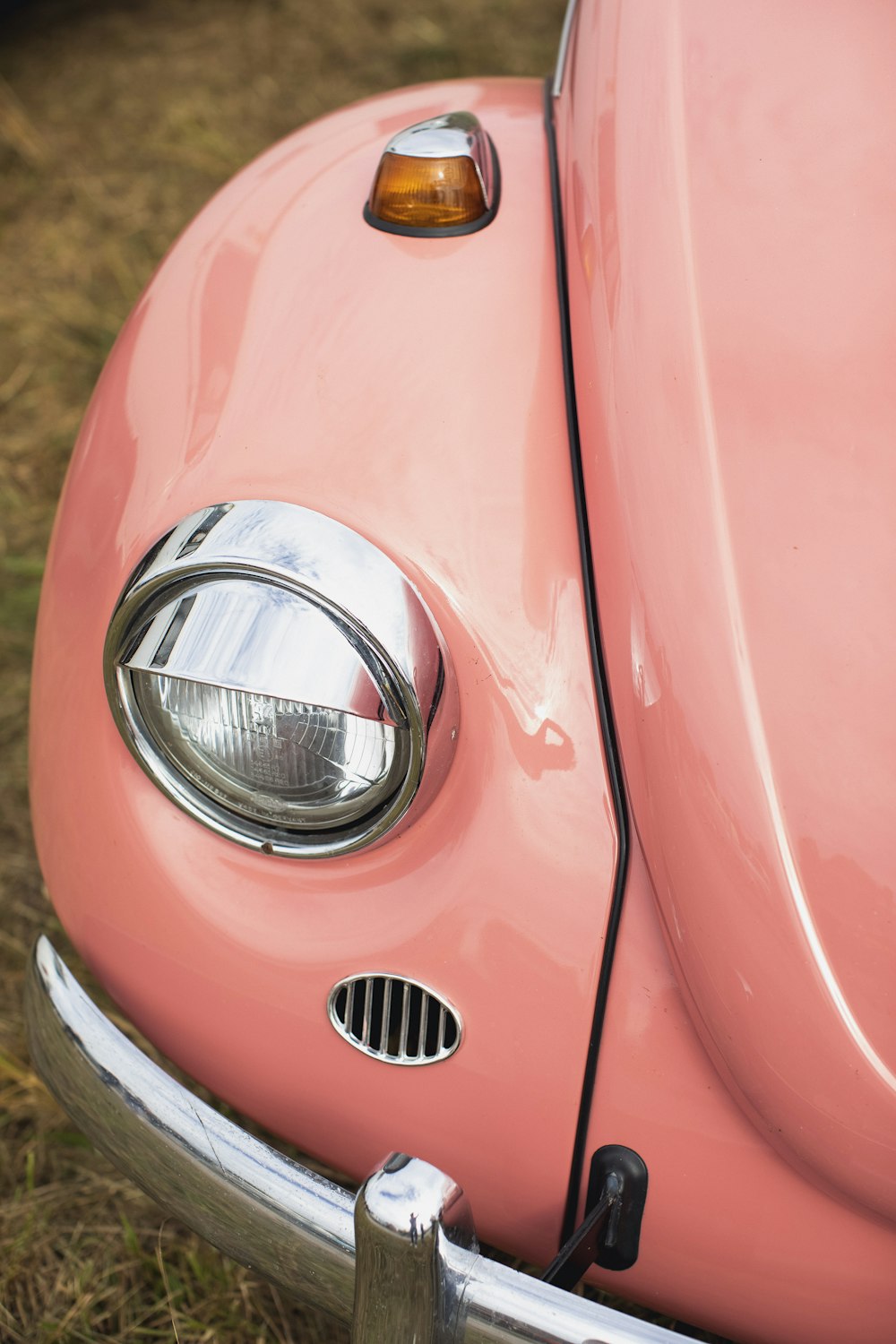 a close up of the front end of a pink car