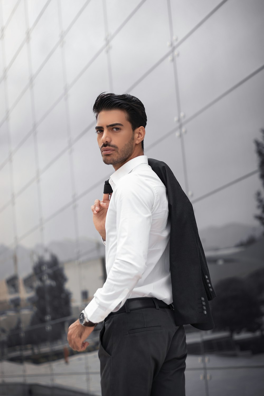 a man standing in front of a glass building