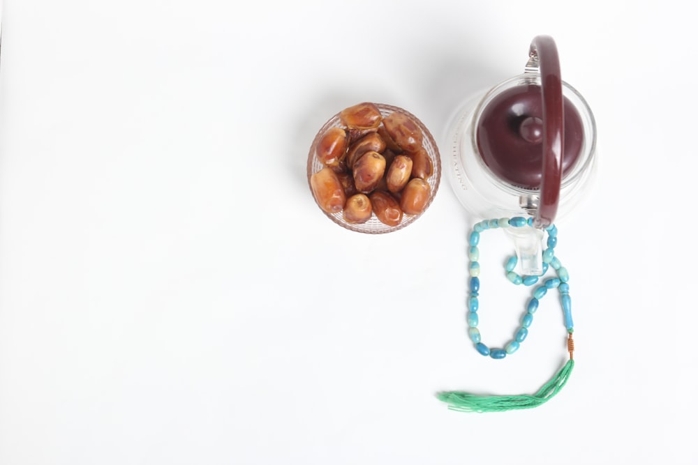 a glass jar filled with nuts next to a string