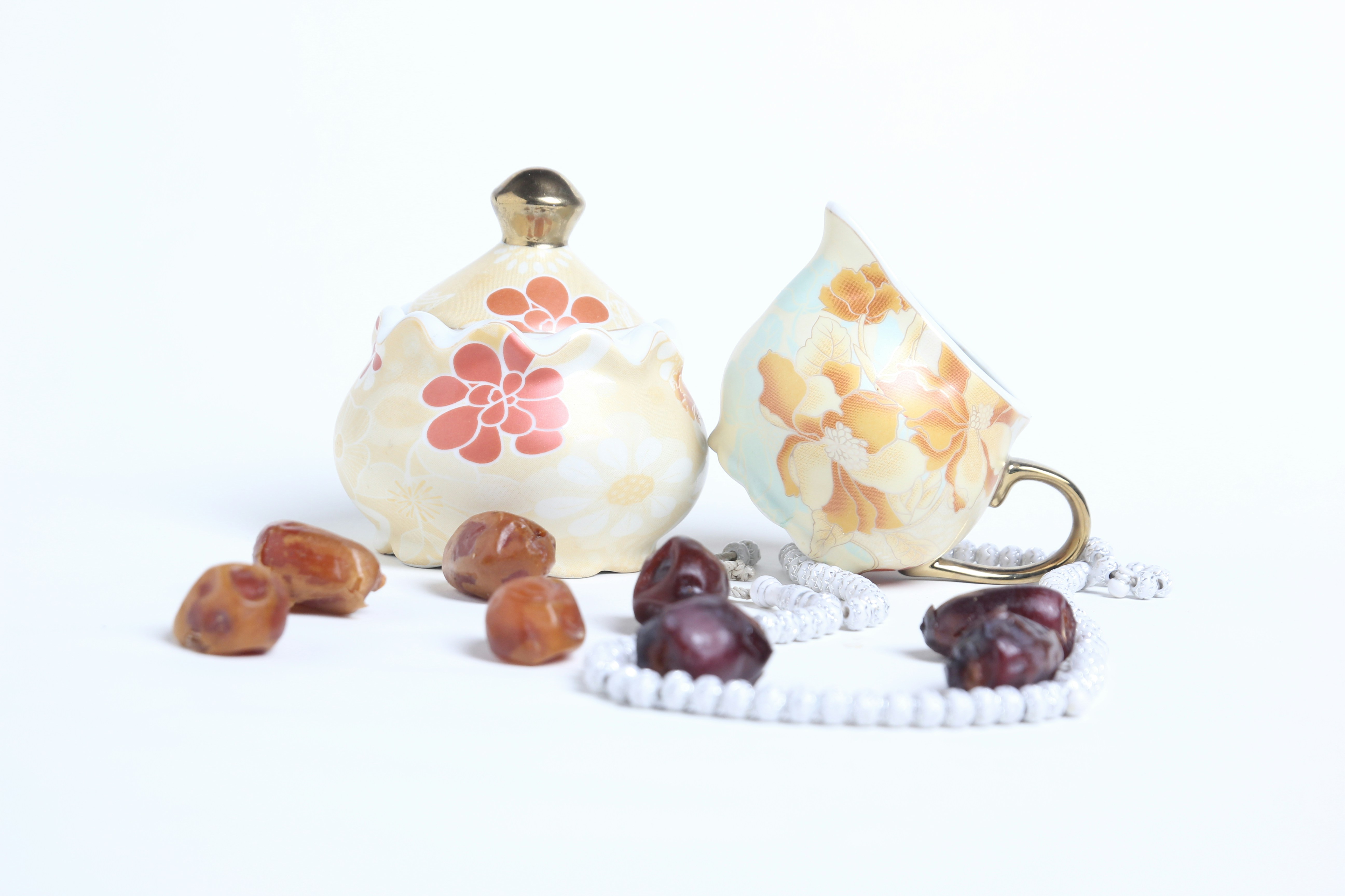 teko teh dan cangkir dengan sendok di atas meja