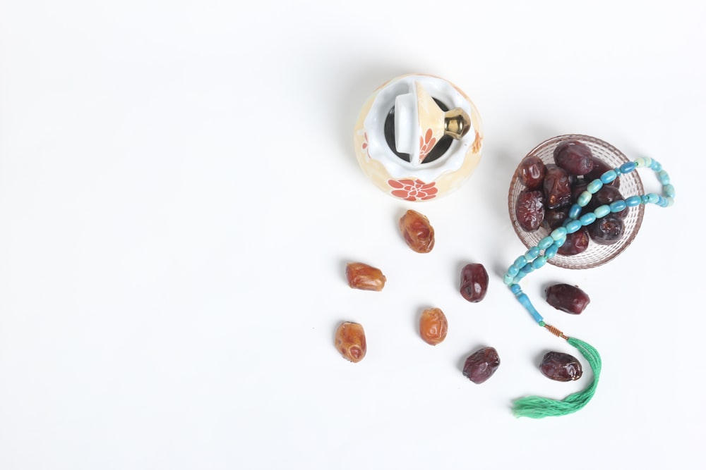 a bowl of olives and a bowl of dates on a white surface