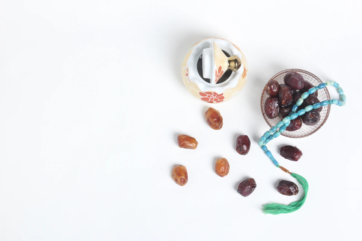 A bowl of olives and a bowl of dates on a white surface