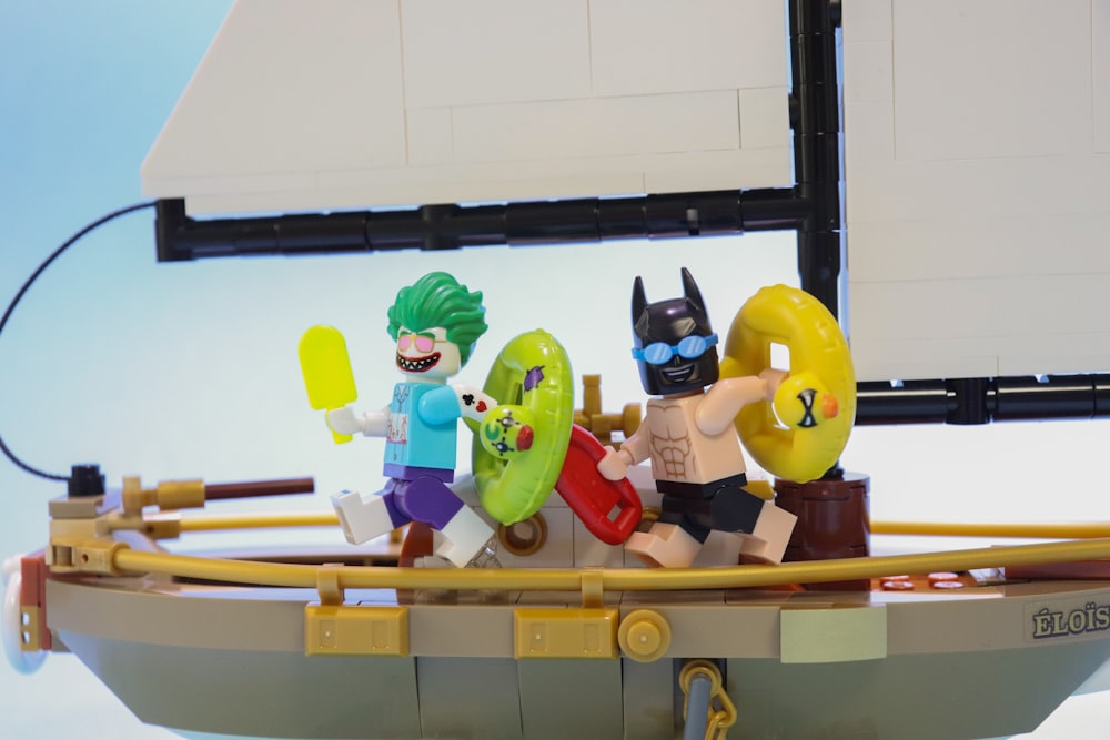 a lego boat with a batman and joker on it