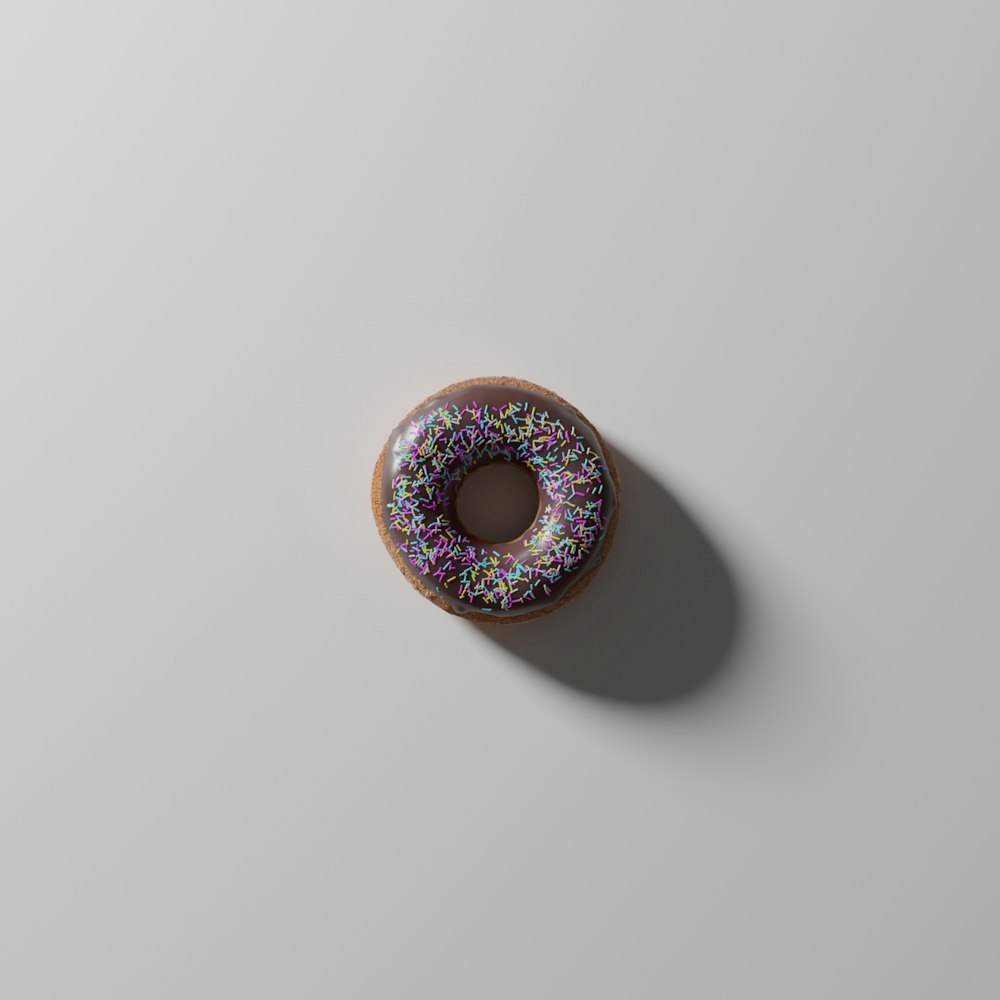 a donut with sprinkles on a white surface