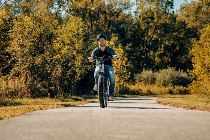 a man riding a motorcycle down a rural road