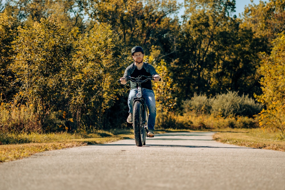 a man riding a motorcycle down a rural road