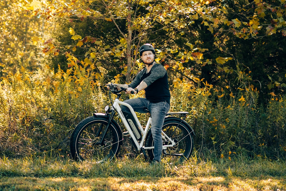 a man is sitting on a bicycle in the woods