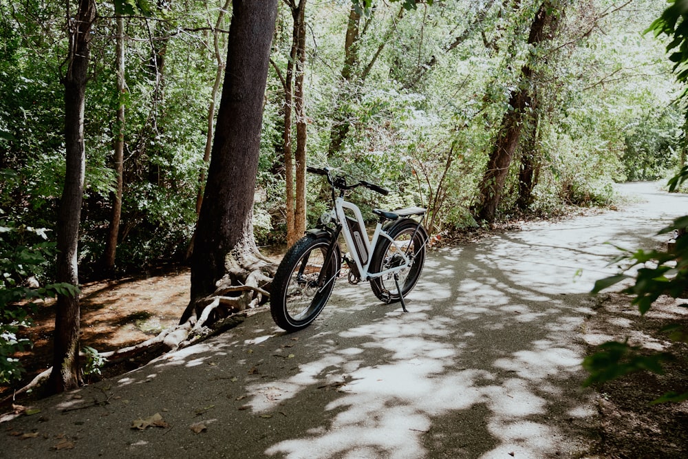 a bicycle parked on a path in the woods