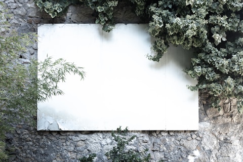 a white sheet of paper sitting on top of a stone wall